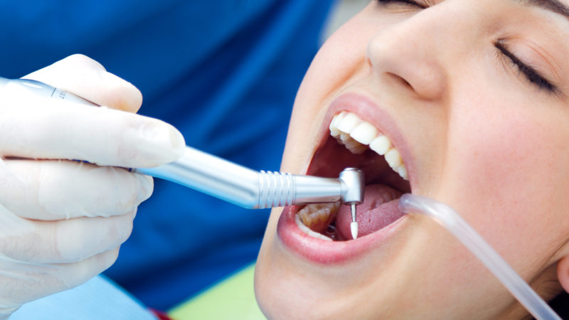 Medical scene of cute young woman at the dentist.